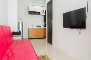 泗水Spacious 1BR Apartment at Menara Rungkut By Travelio的客厅配有红色沙发和平面电视