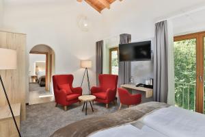 奥伯斯特多夫Elements Hotel Christlessee的酒店客房,配有一张床和两张红色椅子