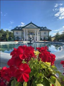 比亚韦斯托克瓦恰米切赫酒店的游泳池前有红花的房子