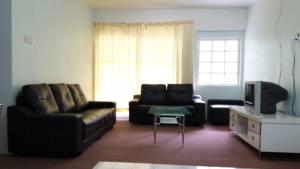 丹那拉打MERLIN HOME DESA ANTHURIUM的带沙发和电视的客厅