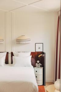 巴黎Hôtel Wallace - Orso Hotels的卧室配有白色的床和白色床头柜。