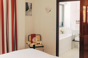 巴黎Hôtel Wallace - Orso Hotels的一间卧室配有一张床、一把椅子和浴缸
