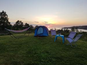 LyngstadLeite Telt Camping的田野里的帐篷、两把椅子和一张桌子