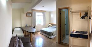 瓜鲁柳斯瓜鲁柳斯黑貂酒店的小房间设有一张床和一张书桌