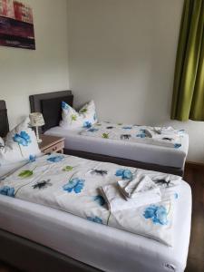 巴特埃尔斯特Zollhaus的两张床位于带蓝色鲜花的房间