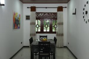 坦加拉Nima villa的一间带桌椅和窗户的用餐室