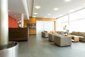 弗赖辛ACHAT Hotel Corbin München Airport的大堂内带沙发和椅子的客厅