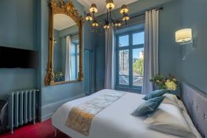 里摩日巴黎酒店的一间卧室配有一张大床和镜子