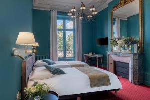 里摩日巴黎酒店的一间蓝色卧室,配有两张床和镜子