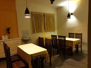 卡特勒格默Shiva Rest Katharagama的一间带2张桌子和椅子的用餐室
