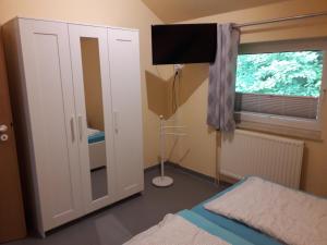 帕彭堡Ferienhaus Pusteblume的一间卧室设有一张床、一台电视和一个窗口。