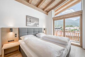 蒂罗尔-泽费尔德AlpenParks Chalet & Apartment Alpina Seefeld的一间卧室设有一张大床和一个大窗户