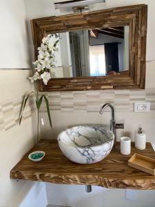 卡拉拉Ca LuBella的浴室的柜台设有水槽和镜子
