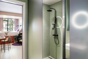 鹿特丹Hotel Unplugged的一间带淋浴的浴室,卧室里有一个女人