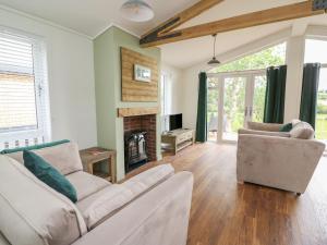 拉尼德洛伊斯Ash Lodge的客厅设有两张沙发和一个壁炉