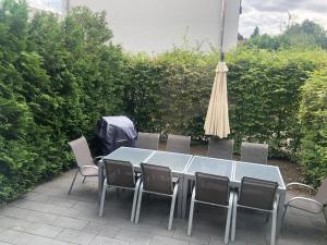 美因茨Familienfreundliches Ferienhaus Bahnstr 30C的庭院里配有桌椅和遮阳伞