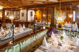 采尔马特桑尼酒店的一间设有白色桌子和吊灯的用餐室
