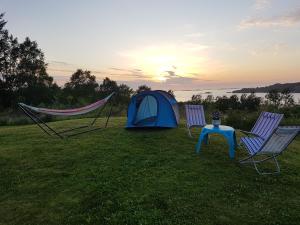 LyngstadLeite Telt Camping的帐篷、2把椅子、1张桌子和1顶帐篷