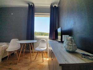 JasieńHostel AgMa的客房设有桌椅和窗户。