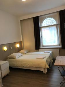 阿姆斯特丹hotel Oosterpark的带窗户的客房内的两张床