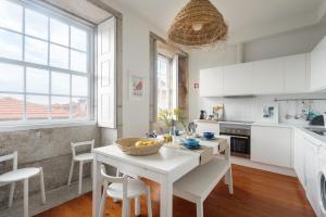 波尔图Own Places Clérigos Apartments的厨房配有白色橱柜和桌椅