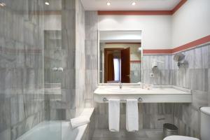 塞维利亚穆里略酒店的一间带水槽、卫生间和镜子的浴室