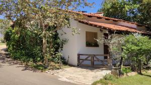 皮雷诺波利斯Chalés Beira Rio的一座白色的小房子,有门和树木