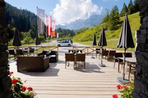 上柯尼希山麓米尔巴赫Hotel-Restaurant Bike&Snow Lederer的路边设有桌子和遮阳伞的餐厅