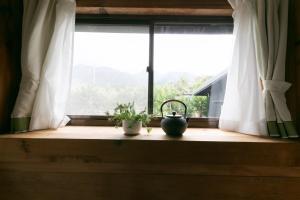 YudomariKumage-gun - House - Vacation STAY 89468的木窗台上一扇带植物的窗户