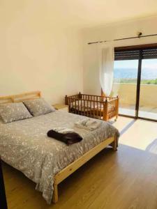 孔迪镇Carminho beach house的一间卧室设有一张床和一个大窗户