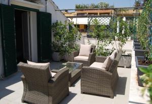 罗马因佩丽亚套房酒店的庭院设有藤椅和玻璃桌
