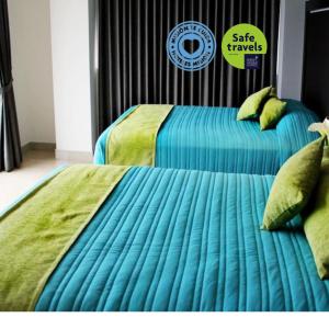 贾拉普Mision Express Xalapa Centro的卧室内的两张床和蓝色棉被