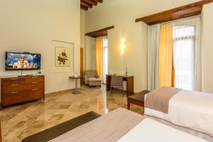 瓦哈卡市帕拉多阿尔卡拉酒店的酒店客房,配有床和电视