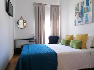圣巴托洛梅乌迪梅西尼什Guia Guest House的一间卧室配有一张带蓝色毯子的床和窗户。
