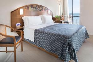 贝拉里亚-伊贾马里纳斯特兰德酒店的一间卧室配有一张大床,提供蓝白色的毯子
