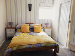 哈特伯瑞Hartpury B&B的一间卧室配有一张带黄色枕头的床