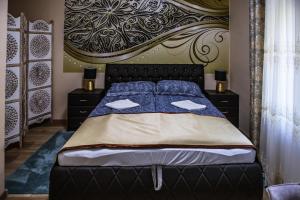 毛科Villa Apartman的一间卧室配有一张带大床头板的床