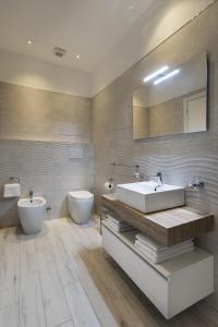 斯波莱托Gli Archi Spoleto的一间带水槽、卫生间和镜子的浴室