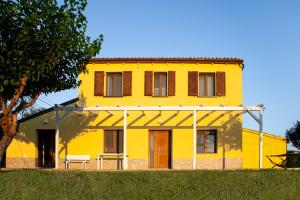 格拉达拉La Casa Del Sole的前面有一棵树的黄色房子