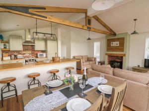 拉尼德洛伊斯Hazel Lodge的厨房以及带桌椅的起居室。