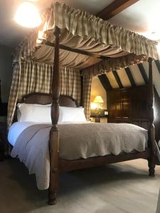 AldertonBells Cottage的卧室内一张带木架的天蓬床