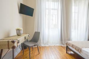 阿威罗Patio79 Aveiro的一间卧室配有书桌、床和窗户。