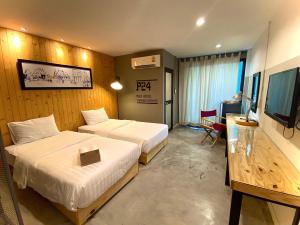 曼谷P24卡塞特酒店的酒店客房设有两张床和电视。