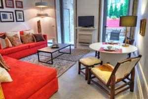 波尔图三房子卧室公寓的客厅配有红色的沙发和桌子