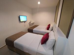 努沙再也Crescendo Boutique Hotel的酒店客房设有两张床和电视。