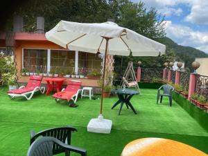 百乐·奥拉内斯蒂Casa Nicoli的草地上带椅子和遮阳伞的天井