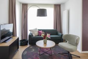朗格奥Hotel Upstalsboom Langeoog的客厅配有沙发、椅子和桌子
