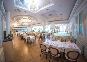 斯捷尔利塔马克Grand Hotel Vostok的一间设有白色桌椅的用餐室