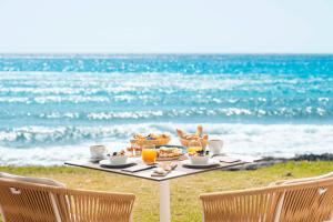 坎亚梅尔梅尔比奇Spa酒店 - 仅限成人的海滩上的餐桌,包括食物和饮料