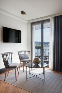 圣塞瓦斯蒂安桑塞贝酒店的客厅配有两把椅子和电视